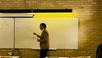 Docente junto ao quadro durante uma aula